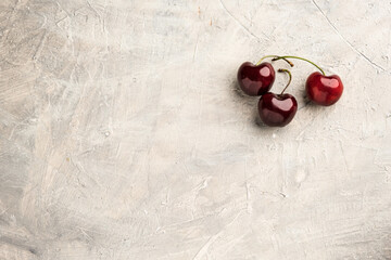 Obraz na płótnie Canvas Ripe sweet cherry in ceramic bowl at concrete background