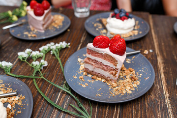 Sweet cakes with summer berries on a wooden table. Party, sweet table. Summer offer desserts in the restaurant.
