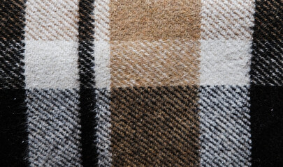 Brown plaid blanket. Close up view of a full size background texture. Textile piece of cloth. Warming up cozy material to cover up when studying or working from home in isolation. Seasonal coziness.