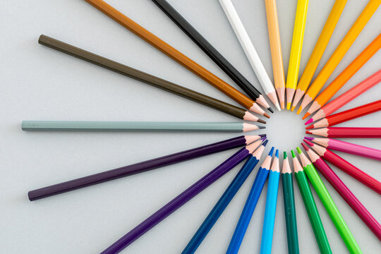a set of colourful pencils on a table in a circle shape 