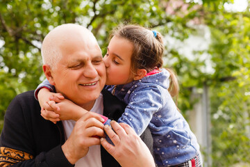 Fototapeta premium Funny lifestyle portrait of grandchild embracing grandfather