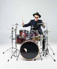 Fototapeta premium Handsome young man behind the drum kit isolated on a white background