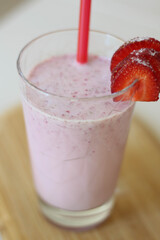 Delicious milk cocktail made of fresh strawberries in glass. Pink