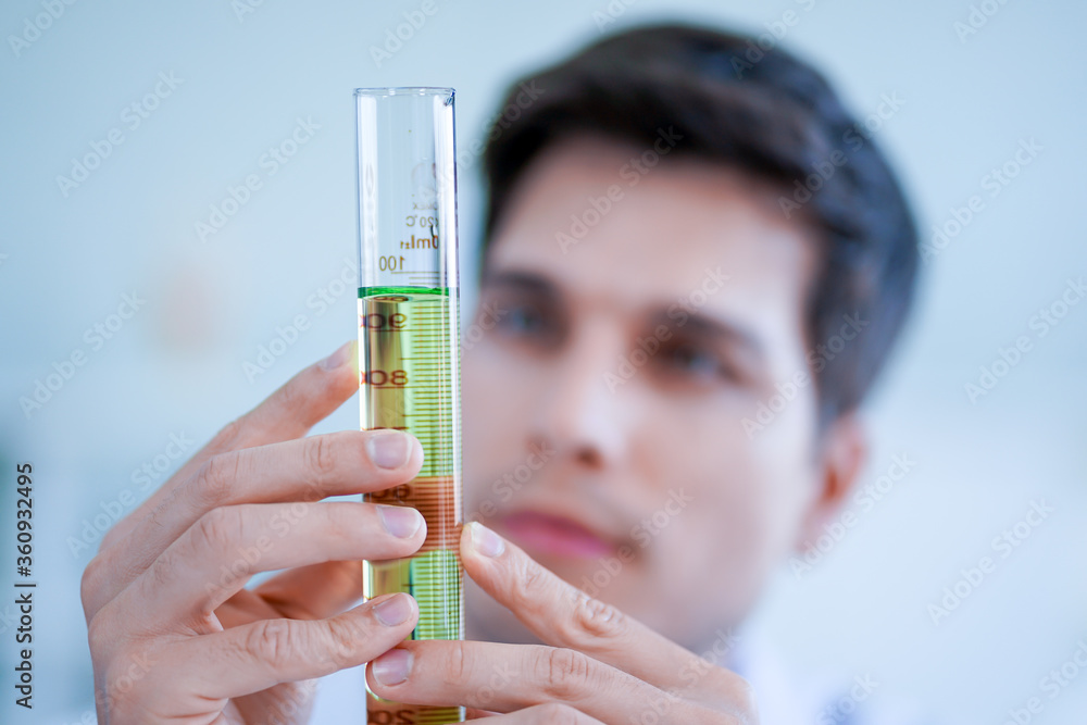 Wall mural caucasian scientist wearing protective glasses and lab white gown working in medical laboratory. vir