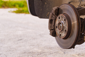 Old and dirty rear dump break of the vehicle for repair. Brakes on a car with removed wheel. Detail image of cars break assembly before repair.