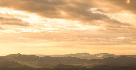 Mountains on the horizon with an orange sky during a sunset
