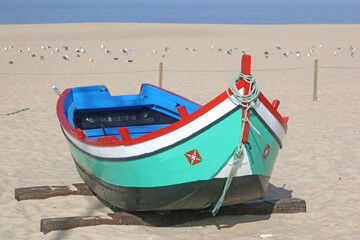 Fototapeta premium Traditional fishing boat on Nazare beach, Portugal 