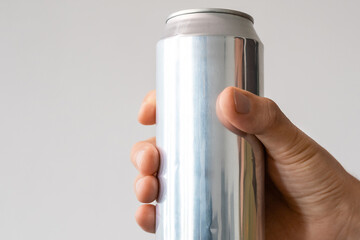 aluminum can with carbonated drink in a male hand