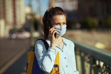 Fototapeta premium stylish female in blue blouse using phone outdoors in city
