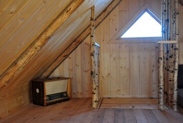wooden interior triangular window . old radio solid birch railing.