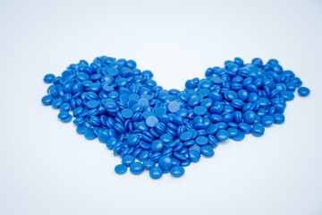 blue pills are piled up on a white background