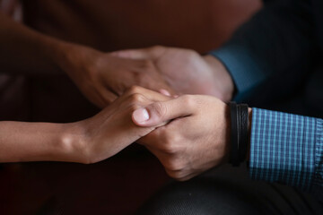 Multiethnic couple in love holding hands close up image. Mixed race woman and caucasian man having heart-to-heart talk showing protection, give psychological aid to friend, declaration of love concept