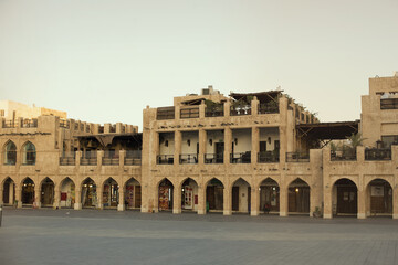 Fototapeta premium Souq Waqif during quarantine. Empty area in front of the market. Shops and cafes do not work. Sunset. Orange sky Mosque