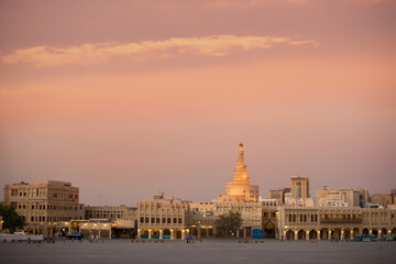 Fototapeta premium Souq Waqif during quarantine. Empty area in front of the market. Shops and cafes do not work. Sunset. Orange sky Mosque