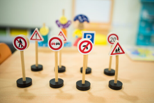 Little children`s road signs. Training children in road traffic. Teaching children in kindergarten and elementary school how to recognize traffic signs. Signs made of wood.Game for children. - Powered by Adobe
