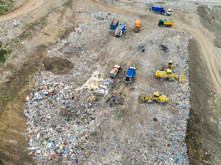 Fototapeta na wymiar Garbage pile in trash dump or landfill. Dump trucks and excavators unloading waste. 