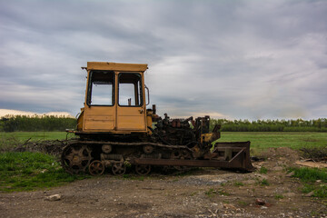 Broken tractor on tracks in the field