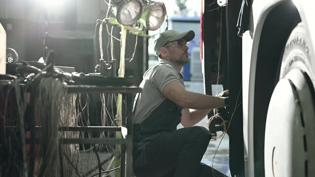 Troubleshooting Male Mechanic Trying To Figure Out Reasons For Vehicle Electrical Failure. 