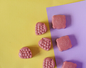 Chocolate candies on a purple and yellow background. Place for photo. Advertising photo.
