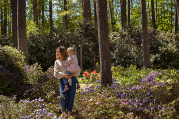 Mother and daughter walking in rhododendron botanical garden.
