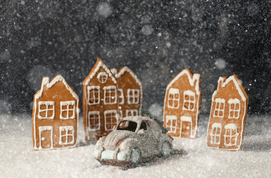 Christmas sweets toys. Toy car an gingerbread cookie house on snowy ground