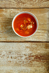 Dish with thai tom yam soup on a wooden table. Vertical