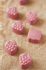 On a burlap of pink chocolate candy.
