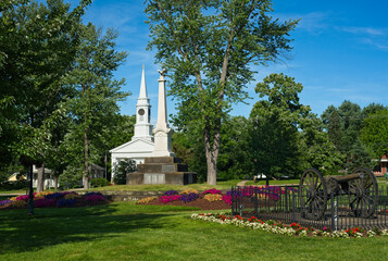 Summer on Twinsburg Square with Civil War monument and cannon in front of a historic old church