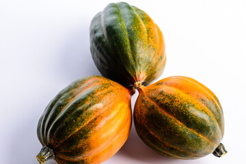 Three green and orange acorn pumpkins on a white background.