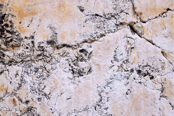 Marble stone wall, cement wall cracked and uneven, weathered wall with space for text, no person and horizontal

