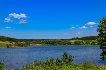 Obraz na płótnie Canvas Summer landscape with beautiful lake, green meadows, hills, trees and blue sky