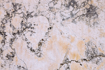 Marble stone wall, cement wall cracked and uneven, weathered wall with space for text, no person and horizontal

