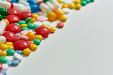 Close up of different pills, capsules scattered diagonally over white background. Health care, vitamins and treatment concept