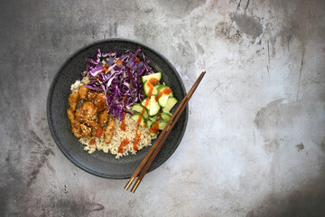 Fototapeta na wymiar Korean Chicken Bulgogi Bowl with Brown Rice, Cabbage and Cucumber