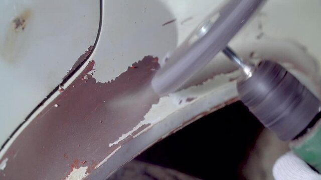 Body master grind old paint and rust from car body using drill with scotch brite circle