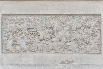 decorative stucco in a grape leaves form on an old house wall