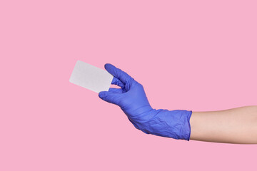 A hand in a surgical glove holds a business card or blank paper isolated.