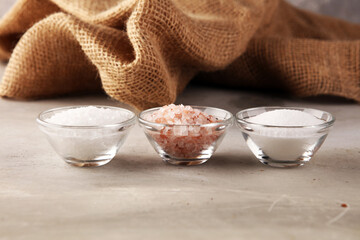 Sea salt and himalayan on spoon. Crystals of salt on background