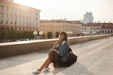 Woman tourist in hipster outfit on the city street on a summer day, summertime fashion