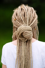 hairstyle with dreadlocks, girl with braided hair in dreadlocks, blonde rear view,