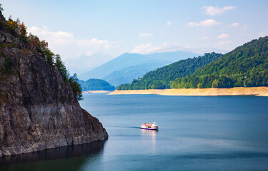 A beautiful landscape with the Vidra lake. A ship on the lake. The calm water of the storage lake Vidra.
