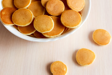Pancake cereal in a white bowl, tiny trend pancakes. Breakfast food concept.