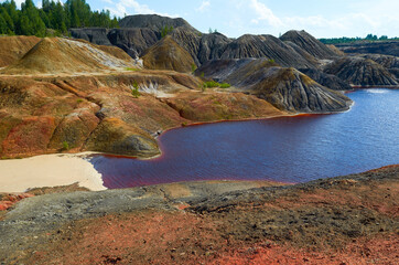 mountains of red clay in the Urals. The color of iron and the atmosphere of Mars. Unusual terrain. Red river.