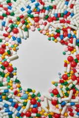 Different pills, capsules scattered in the shape of circle over white background. Health care, vitamins and treatment concept
