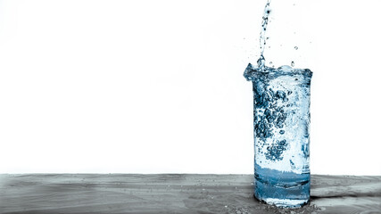 Fresh blue water pouring into a clear glass drink isolated on white background. Natural resource concept