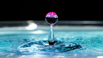 Water drop sphere splash macro background. Splashing droplet in pool close up