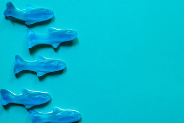 blue jelly sweets top view. Delicious marmalade. Candy in the shape of fish on blue background with...