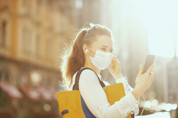 elegant woman having video meeting outdoors in city