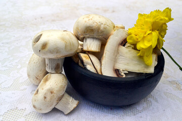 mushrooms in clay bowl on table with lacy towel