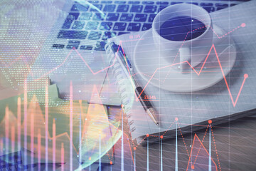 Double exposure of forex chart drawing and desktop with coffee and items on table background. Concept of financial market trading